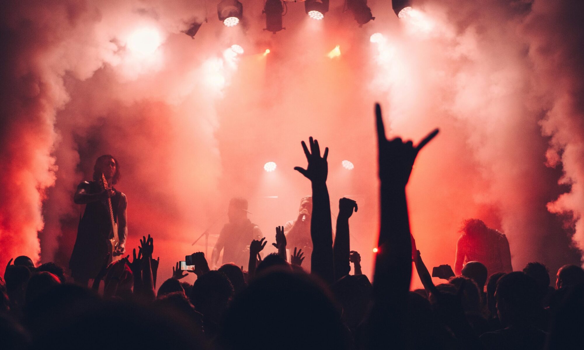 Dynamic scene of a rock band performing live with an enthusiastic audience and vibrant stage lights.